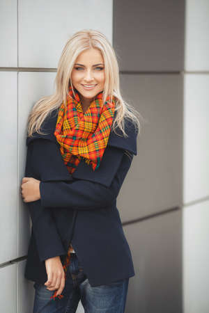 Portrait of beautiful young blonde woman walking outdoors in autumnの写真素材