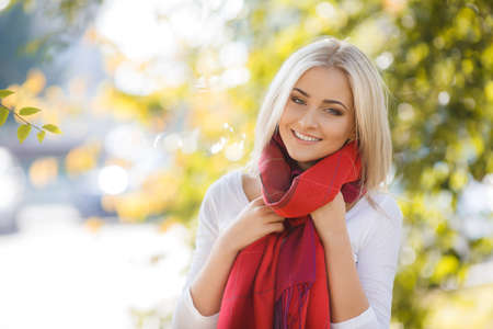 Close up portrait of young blonde beautiful woman in warm autumn scarf  Ourdoors の写真素材