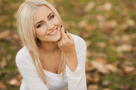 Close up portrait of young blonde beautiful woman in warm autumn scarf  Ourdoors の写真素材