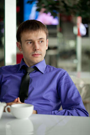 Business man with the laptop drinks coffee in cafeの写真素材