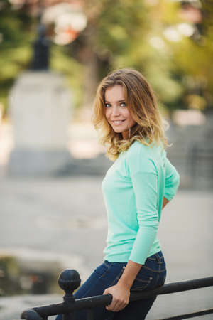 Portrait of a young beautiful smiling blonde woman outdoorsの写真素材