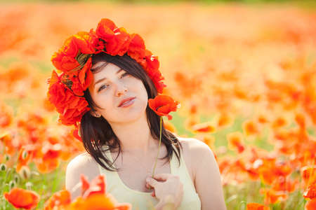 Beautiful woman in poppy wreath in summer poppy field  Outdoor portrait の写真素材