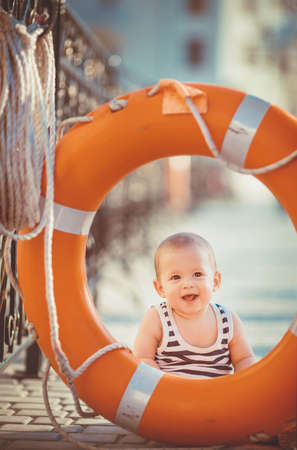 Portrait of happy little boy playing outdoors at dock near the sea