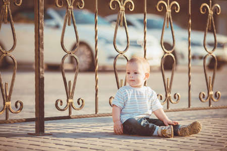 Portrait of happy little boy playing outdoors at dock near the seaの写真素材