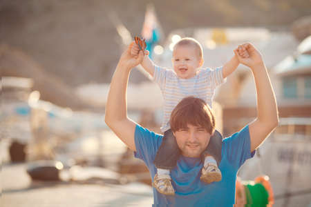 Father playing with his son on the pier near yacht club in summer  Outdoor