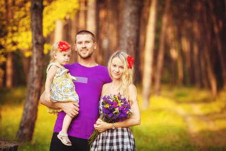 Happy family having fun outdoors in spring park against natural green backgroundの写真素材