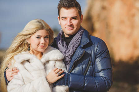 Portrait of young embracing couple  Man and woman in autumn scenery and mountains behind, outdoorの写真素材