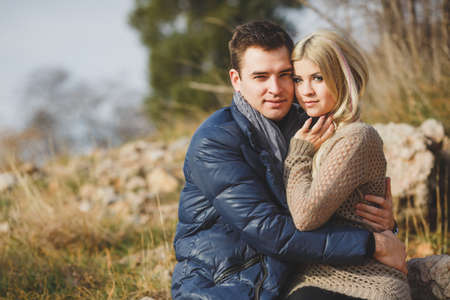 Portrait of young embracing couple  Man and woman in autumn scenery and mountains behind, outdoorの写真素材
