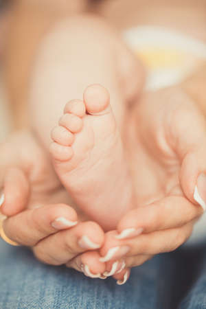 Masseur massaging little baby s foot, shallow focus