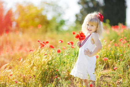 Cute child girl in poppy fieldの写真素材