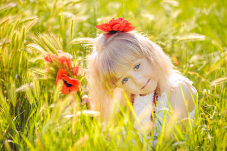Cute child girl in poppy fieldの写真素材