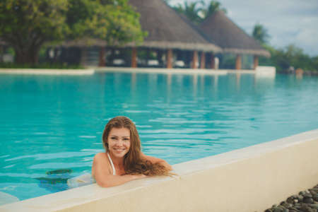 portrait of Beautiful woman resting in the pool at Maldives islandsの写真素材
