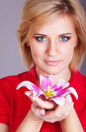 Fresh clear healthy skin on the face of beautiful woman with flower  studio portraitの写真素材