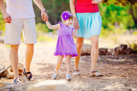 Happy young family with child resting outdoors in summer parkの写真素材