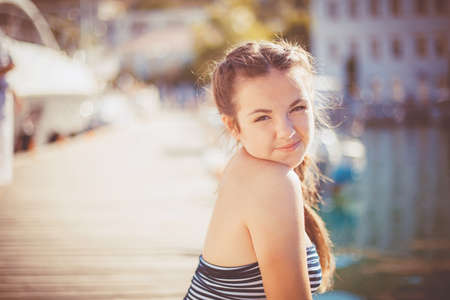 Summer portrait of girl on the yacht harbor waiting for his captainの写真素材