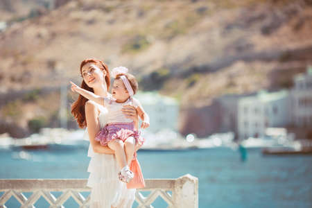 Happy woman with daughter resting at beach in summer outdoorの写真素材