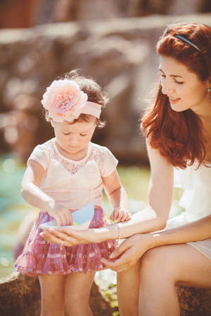 Happy woman with daughter resting at beach in summer outdoorの写真素材