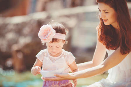 Happy woman with daughter resting at beach in summer outdoorの写真素材