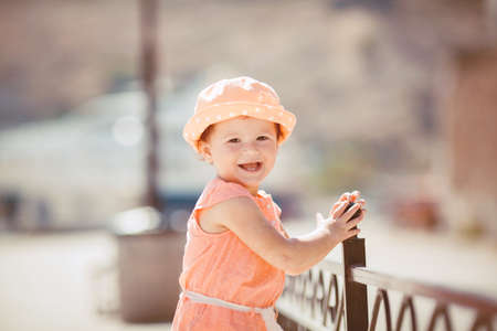Cute little girl playing near the sea in the summer outdoorsの写真素材