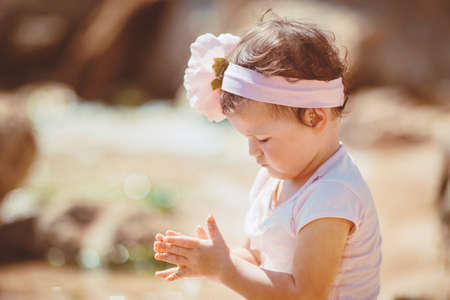 Cute little girl playing near the sea in the summer outdoorsの写真素材