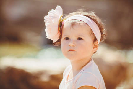 Cute little girl playing near the sea in the summer outdoorsの写真素材