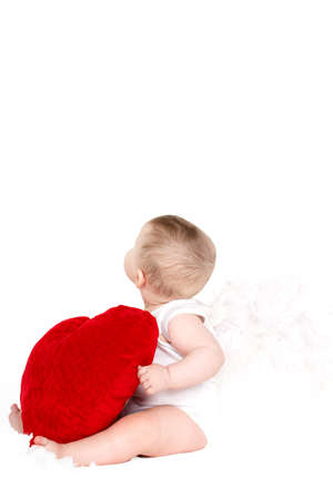 portrait of a Cute adorable little valentine angel with red soft heart isolated on white backgroundの写真素材