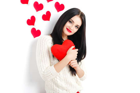 Valentine s Day  Portrait of Beautiful smiling brunette woman with heart in her hands and behind isolated on white backgroundの写真素材