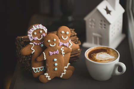 Smiling gingerbread man standing next to a Cup of coffee at the window, close with shallow DOF copy space for text in Internetの写真素材