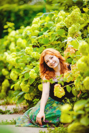 Portrait of a beautiful young woman in a summer green Parkの写真素材