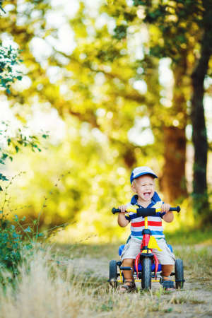 Portrait of a smiling boy a children s Bicycle in a green Parkの写真素材
