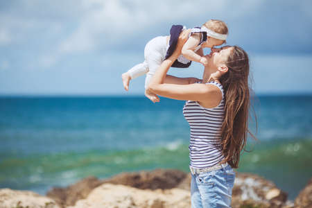 portrait of Happy Family of two mother and child having fun by the Sea shore