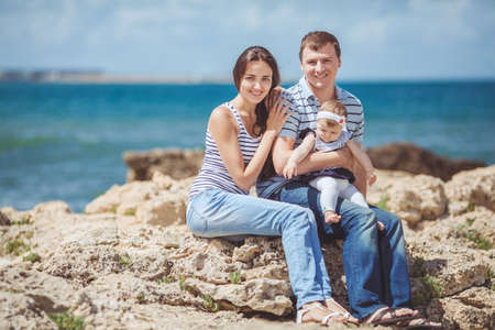 portrait of family of three having fun together by the ocean shore and enjoying the view  Outdoorsの写真素材