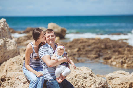 portrait of family of three having fun together by the ocean shore and enjoying the view  Outdoorsの写真素材
