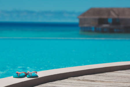 Beach Slippers on a wooden platform on the oceanの写真素材