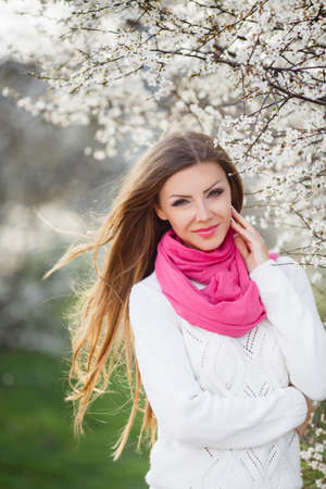 portrait of young brunette in the spring blooming gardenの写真素材