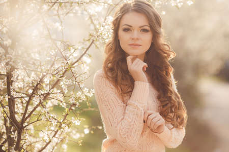 Beautiful woman enjoying outdoors, nice female  pretty girl relaxing outdoor, having fun, happy young lady and spring green nature and blooming trees, harmony conceptの写真素材