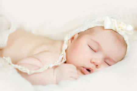 Newborn baby sleeping on a bedの写真素材