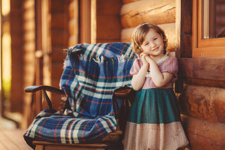beautiful young girl portrait playing outdoors on wooden terraceの写真素材