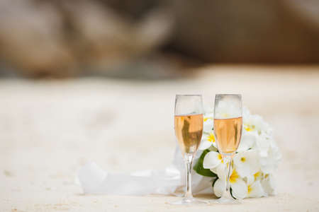 wedding bouquet of frangipani and champagne glassesの写真素材