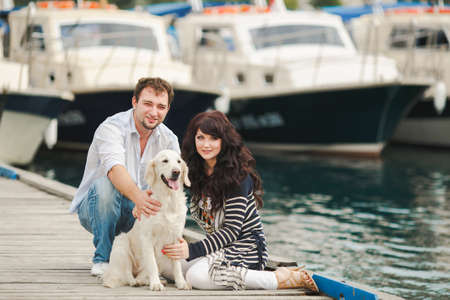Young couple with dog posing at historical town sunny day  Couple playing with their dog in harborの写真素材