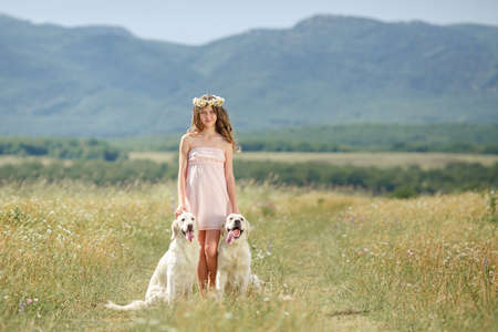 Beautiful woman playing with her dog  Outdoor portrait  series  Woman embraces golden retriever lying on the green grass  Woman playing with her dog outdoorsの写真素材