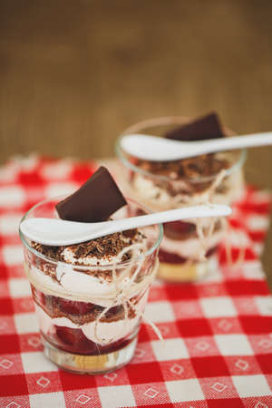 Glasses with cherries and chocolate parfait with whipped sour cream. Shallow dof. Delicous...
