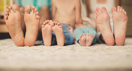 Feet of parents and legs of a baby