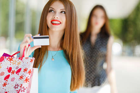 Young woman with credit card and shopping bagsの写真素材