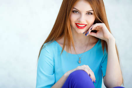 glamorous portrait of young beautiful woman in bright clothes. red lips. Summer portrait of a beautiful young Caucasian girl with red straight hair. fashion portrait.の写真素材