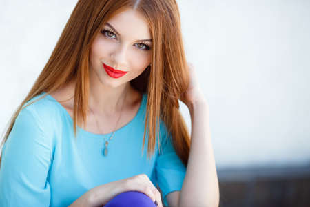 glamorous portrait of young beautiful woman in bright clothes. red lips. Summer portrait of a beautiful young Caucasian girl with red straight hair. fashion portrait.の写真素材