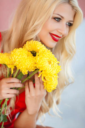 Close-up portrait of attractive blonde woman with yellow flowers. Summer portrait outdoorの写真素材