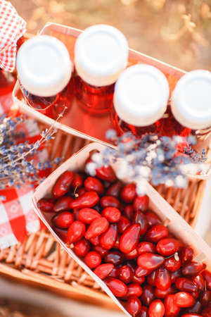Different berries in a wicker basket with juice on the home desktop.の写真素材