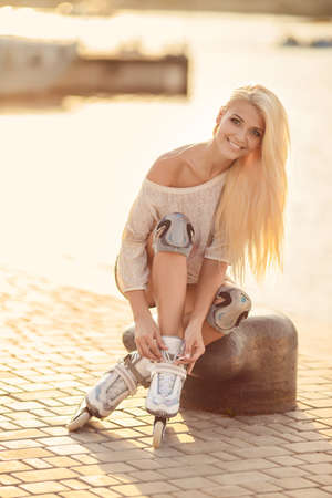 Young girl enjoys skating on roller skates in the park. Woman outdoors. Beautiful girl on roller skates in the park.の写真素材