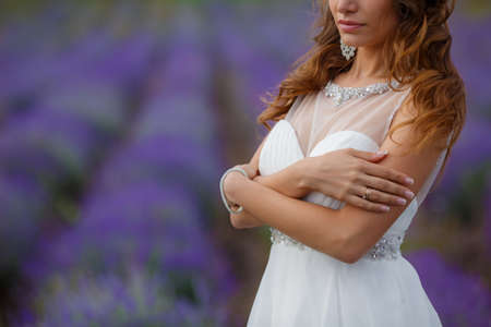 Beautiful bride smiling in her wedding day, in a lavender fieldの写真素材